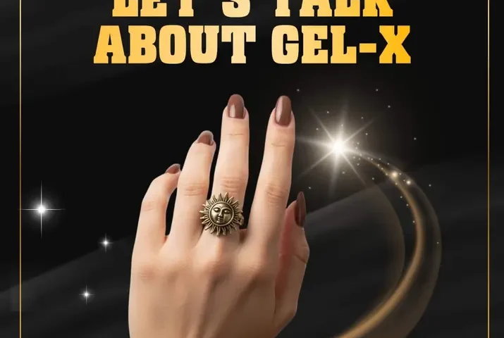 Hand with Gel-X nails, sun-themed ring, chunky bracelet, sparkly background.